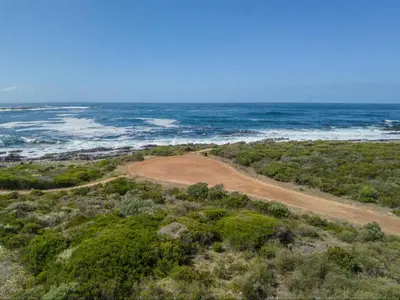an aerial view of a dirt road next to the ocean at Sandbaai Country House in Hermanus