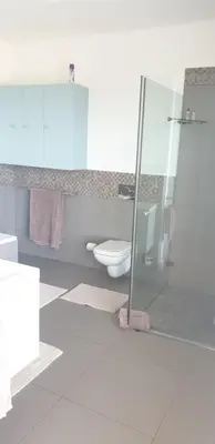 a bathroom with a toilet and a glass shower at Modern spacious home in heart of Cape Winelands in Somerset West