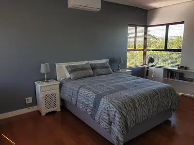 a bedroom with a large bed and a window at Modern spacious home in heart of Cape Winelands in Somerset West
