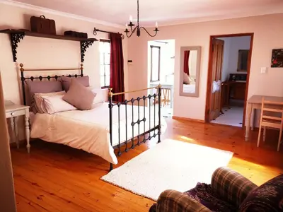 a bedroom with a bed and a living room at Getaway on Peck Way in Edgemead