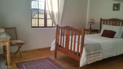 a bedroom with a crib and a window at Getaway on Peck Way in Edgemead