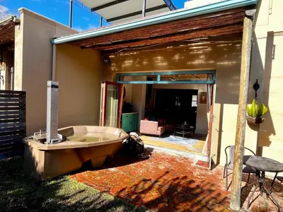 a bath tub sitting outside of a house at Heuwelsig Farm Cottages in Franschhoek