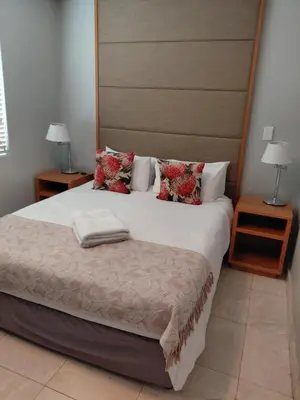 a bedroom with a large bed and two night stands at Cape Beach Penthouse in Cape Town