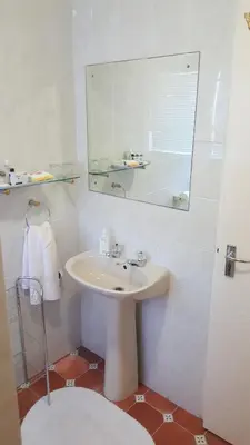 a white bathroom with a sink and a mirror at Durbanville Place - 3 bedroom apartment in Durbanville
