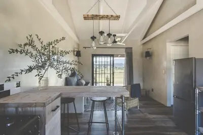 a kitchen with a large wooden table with stools at The Farmstead in Franschhoek