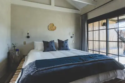 a bedroom with a large bed and a large window at The Farmstead in Franschhoek