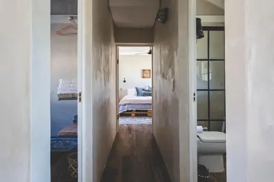 a hallway leading to a bedroom with a bed at The Farmstead in Franschhoek
