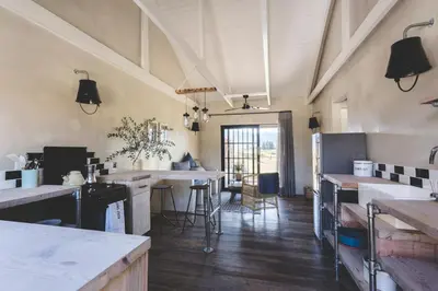 a kitchen with sinks and tables in a room at The Farmstead in Franschhoek