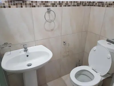 a bathroom with a white toilet and a sink at Fama Lodge Rm13 in Cape Town