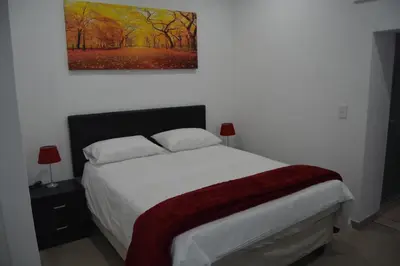 a bedroom with a bed and a painting on the wall at Fama Lodge Rm13 in Cape Town