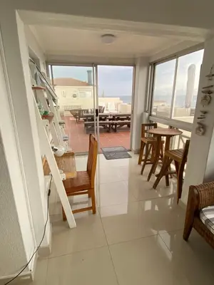 a view of a living room with a table and chairs at Nothing But View in Hermanus