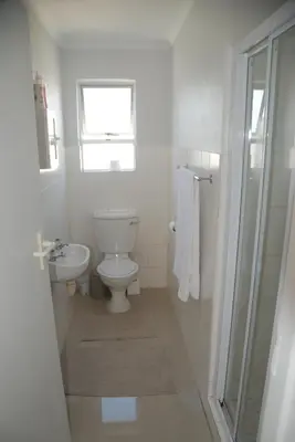 a white bathroom with a toilet and a sink at Nothing But View in Hermanus