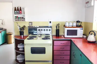 a kitchen with a white stove and a microwave at Norfolkden Beachhouse in Hermanus