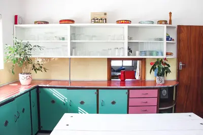 a kitchen with blue and pink cabinets at Norfolkden Beachhouse in Hermanus