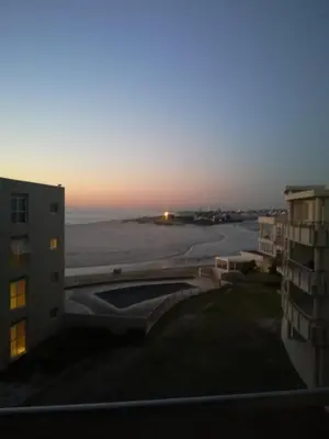 a view of the sunset from the balcony of a building at A310 Lagoon Beach Apartment & Spa in Cape Town