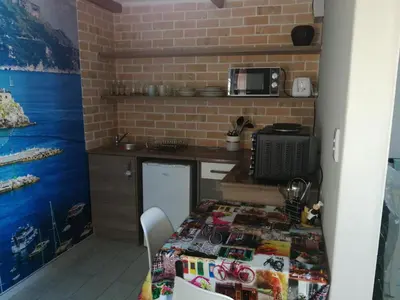 a small kitchen with a table and a microwave at Posto Al Sole - IL Bacio in Bellville