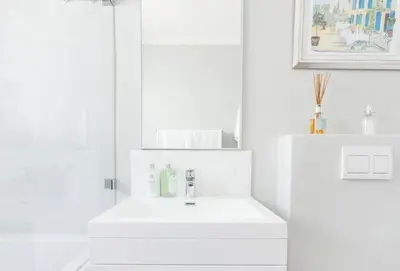 a white bathroom with a sink and a mirror at Art House in Stellenbosch