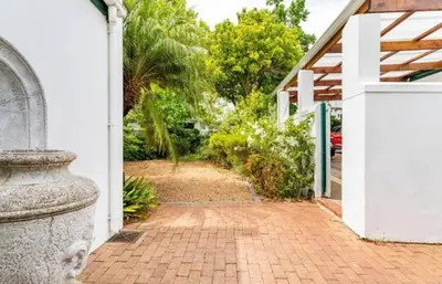 a brick walkway leading to a house with a white door at Art House in Stellenbosch