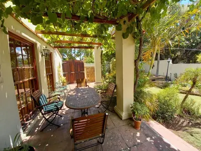 a patio with a table and chairs on a porch at Die Heemhuis in Rawsonville