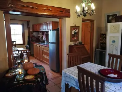 a kitchen with a table and a refrigerator at Die Heemhuis in Rawsonville