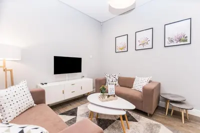 a living room with a couch and a tv at Suburban Bliss Durbanville in Kraaifontein