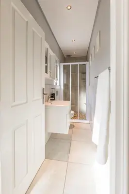 a white bathroom with a sink and a toilet at Suburban Bliss Durbanville in Kraaifontein