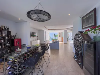 a room with a bar with a lot of wine bottles at Peach on Beach Boutique Guesthouse in Bloubergstrand