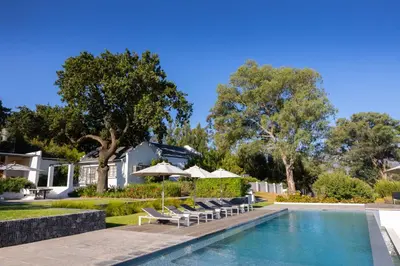 a villa with a swimming pool and lounge chairs at Tempel Wines in Paarl