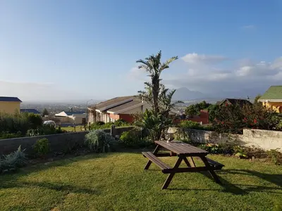 a picnic table sitting in the grass in a yard at Drommedaris in Gordonʼs Bay