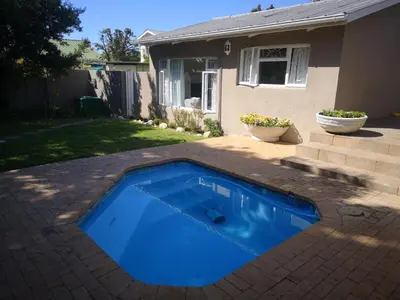 a blue swimming pool in the backyard of a house at On Cloud 9 in Hermanus