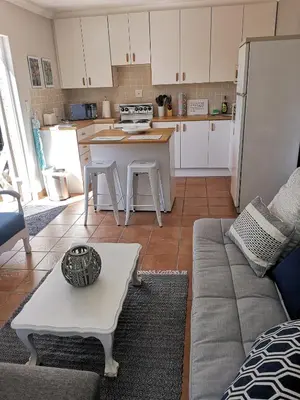 a kitchen and living room with a couch and a table at On Cloud 9 in Hermanus