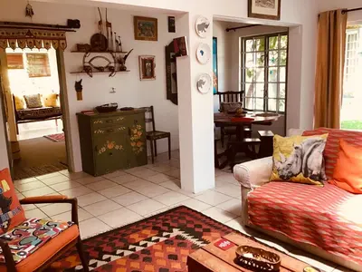 a living room with a couch and a table at Funky cottage in Hermanus