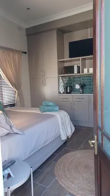 a bedroom with a bed and a table and a tv at Panorama Self Catering 2 in Panorama