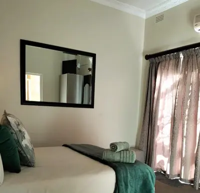 a mirror on the wall above a bed in a room at Panorama Self Catering 2 in Panorama