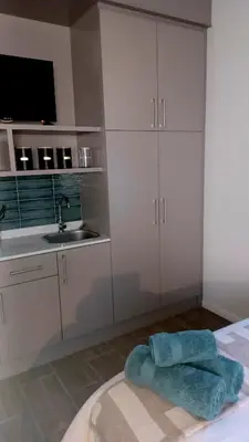 a bedroom with white cabinets and a sink and a bed at Panorama Self Catering 2 in Panorama