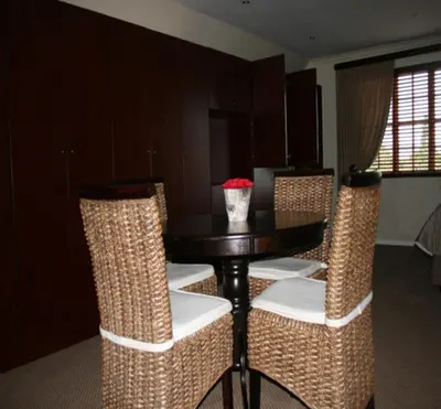 a dining room with a table and wicker chairs at Panorama Self Catering 2 in Panorama