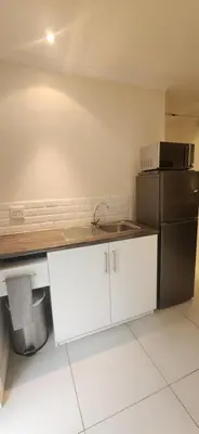 a kitchen with a sink and a refrigerator at Guinea Vine in Stellenbosch