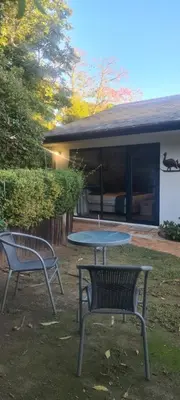 a picnic table and two benches in a yard at Guinea Vine in Stellenbosch