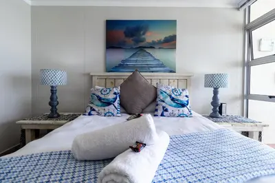 a bedroom with a bed with a painting on the wall at Blakes Terrace 903 in Strand