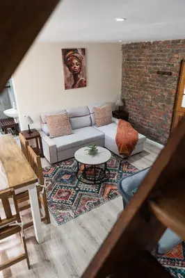 a living room with a couch and a table at Be My Guest Lodge in Bloubergstrand