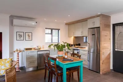 a kitchen with a table and a refrigerator at Mont Angelis in Stellenbosch