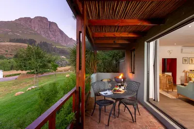 a patio with a table and chairs on a balcony at Mont Angelis in Stellenbosch