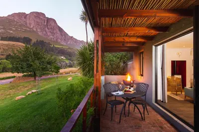 a patio with a table and chairs on a balcony at Mont Angelis in Stellenbosch