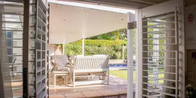 an open door to a patio with a bench at Westbury House Guest House in Cape Town