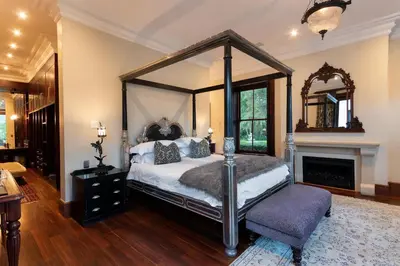 a bedroom with a canopy bed and a fireplace at MolenVliet Estate - Boutique Bed & Breakfast in Stellenbosch