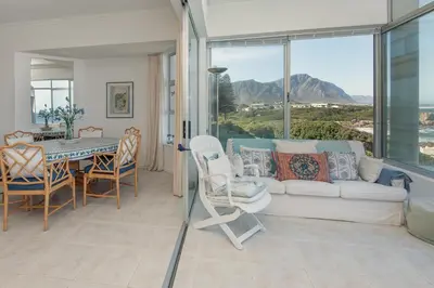 a living room with a couch and a table and chairs at Jewel of Bayview in Hermanus