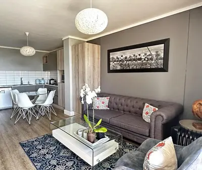 a living room with a couch and a table at WATERS EDGE 103 in Cape Town