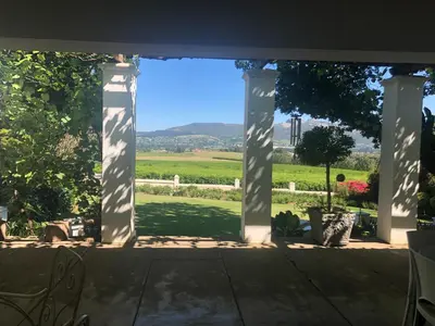 a view from a patio with a view of a field at Hartebeeskraal House in Paarl