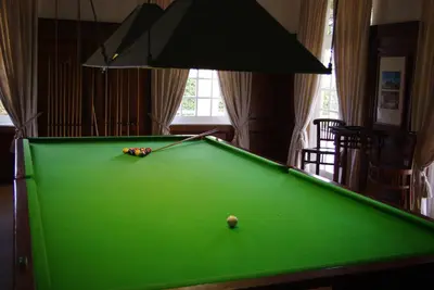 a green pool table with a cue in a room at Lyngrove Wines & Guesthouse in Stellenbosch