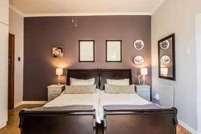 a bedroom with a large bed with two pillows at Greenlawns B&B in Cape Town